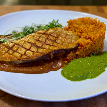 Pan-roasted duck breast with crispy skin, mole poblano, Mexican red rice, and bright green cilantro-lime sauce, inspired by Jake Kelley's Holy Mole dish on MasterChef Season 16.